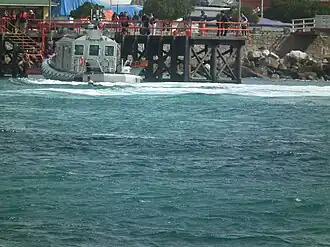 Patrullera Clase Defender atracando en el muelle de El Quisco, Chile. Atrás se ve el Club de yates El Quisco