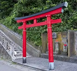El perfil pentagonal típico de un torii kasagi. Tenga en cuenta el "nemaki" negro