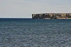 Punta o acantilado que actúa como una división natural de la playa hacia el sur.