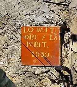 Baldosa de la calle de la Font. «El vecino tiene derecho a la pared. 1850.»