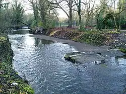 Restos de una presa en el río Brent Mirando hacia el oeste desde la orilla derecha.