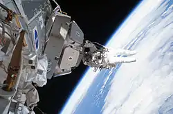 El astronauta Nicholas Patrick agarrado la Cupola tras retirar el aislamiento.