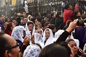 Sahumadoras en la procesión del Señor de los Milagros. Llevan un manto blanco y un hábito morado. Son mujeres de cuarenta años a más.