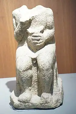 estatua de un brácaro sentado