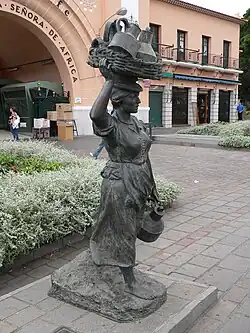 Estatua de "La Lechera" situada frente a la puerta principal del mercado.