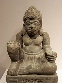 Esta figura sentada puede ser un dharmapala. El pedestal de abajo (no en la foto) presenta una imagen de una cabeza de Kaal (el tiempo.