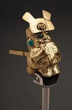 Silbato Moche (cobre dorado) Hombre tocando zampoña. (1 – 800 d.C.) Museo Larco.[7]​