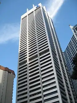 Ground-level view of a 50-storey white tower with a rectangular cross section and dark windows