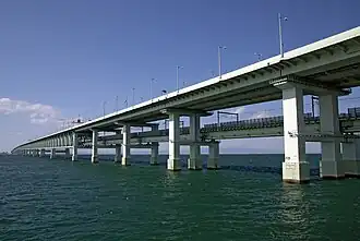 Puente R Sky Gate en el aeropuerto internacional de Kansai, Osaka, Japón, es el puente en celosía de dos pisos más largo del mundo. Soporta tres carriles de tráfico de automóviles en la parte superior y dos de ferrocarril debajo, con nueve tramos de celosía.