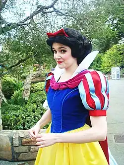 Mujer de cabello negro y piel clara con cosplay de blancanieves.