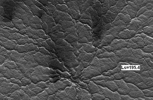 La misma araña 14 días marcianos después, vista por HiRISE. Observe el aumento de ventiladores oscuros causado por la desgasificación del dióxido de carbono que transporta material oscuro.