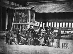 Los directores de la exposición, ante el "shachi" dorado en el patio de Taiseiden (1872)