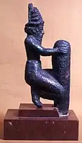 Deidad arrodillada en un clavo de fundación. Periodo de Gudea (Sumeria).