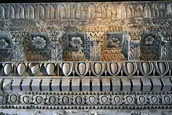 Detalle de la parte superior del entablamento del templo. Se ve entre cada dentellón un motivo compuesto de dos anillos pegados, firma probable del arquitecto Rabirio.