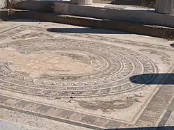 Detalle del pavimento de mosaico que muestra un círculo inscrito en un cuadrado.