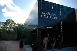 Un edificio negro futurista de estilo monolítico que alberga la Exposición Oficial de Matrix.