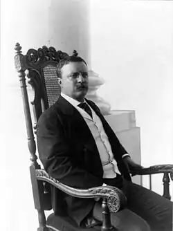 El Presidente Theodore Roosevelt sentado en una silla diseñada por White para el comedor de gala de la Casa Blanca, 1903.