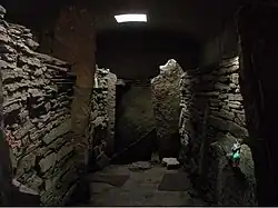 La Tumba de las Águilas es un cairn con cámara, al cual se accede por un estrecho corredor y dentro, como se observa en la fotografía, hay distintos compartimentos.