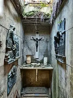 Se ve un nicho, un gran crucifico, en ruinas.