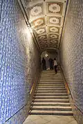 Escalera de mármol que conduce al piso noble. El techo y las cerámicas murales son de estilo italiano.
