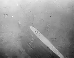 Timón del US Thresher en el fondo.