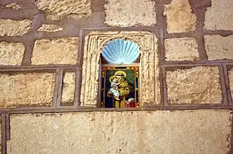 Detalle de ladrillo cerámico con la imagen de san Antonio de Padua en la hornacina avenerada sobre la entrada de la iglesia