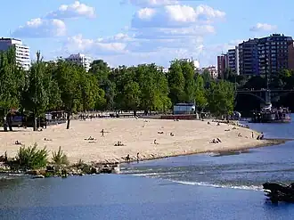 Vista de la playa de las Moreras, en el río Pisuerga, a su paso por la ciudad de Valladolid, España en la que se aprecia la arena similar a las playas del litoral.[4]​
