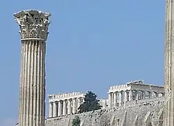 Templo de Zeus Olímpico, Atenas: una de las columnas con el típico capitel corintio. Al fondo, la Acrópolis rematada por el Partenón.