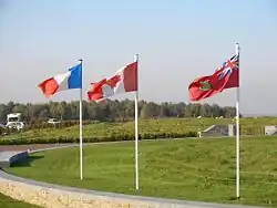 La bandera canadiense en el centro a los lados de la bandera de Francia (a la izquierda) y de la Red Ensign canadiense (a la derecha) en el memorial de Vimy.