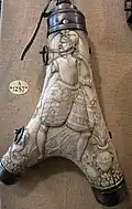 Frasco francés, c. 1590, cornamenta y acero. La figura lleva una pistola y un cuerno en el cinturón