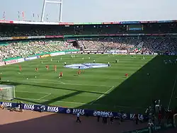 Estadio desde un fondo con la pista de atletismo y los asientos de color verde en 2006.