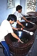 Trabajadores realizando la fijación (eliminación del verde) en hojas de té en una plantación china, 1987.