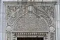 Tímpano de mármol tallado sobre una ventana exterior de la mezquita.