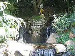 Una pequeña cascada con una estatua de Krishna.
