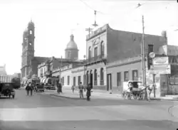 Avenida libertador, con los rieles del tranvía. Del otro lado de la cuadra se ven varios edificios, algunos de ellos con cúpulas. A la izquierda hay un tranvía y el palacio legislativo. A la derecha, por la avenida, va una carreta con caballos.