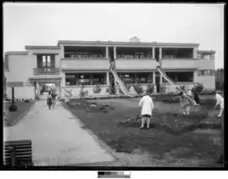 Edificio moderno para la época, de 2 plantas. Desde la planta superior se ven dos toboganes para descenso de niños y niñas.
